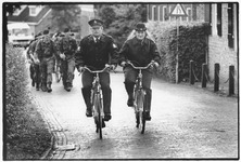 351465 Afbeelding van twee agenten te fiets en daarachter enkele marcherende militairen te Soest.